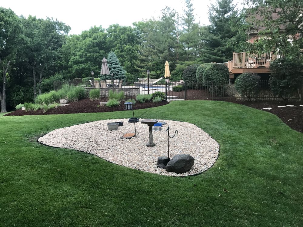 Perfectly tiered natural stone block retaining wall framing a driveway