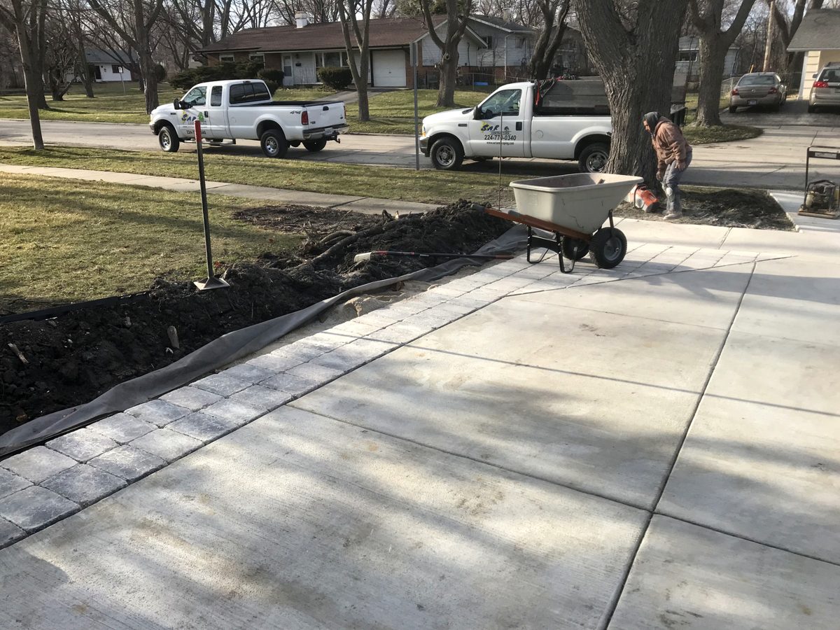 Excavator performing grading and drainage setup in a residential yard